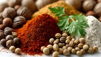 Vibrant red paprika powder, fresh coriander leaf, whole coriander seeds, and rock salt arranged on wooden surface, showcasing aromatic cooking ingredients.