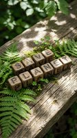 Wooden letter blocks spelling SAVE PLANET arranged on rustic log surrounded by green ferns in natural forest setting for environmental awareness campaigns.
