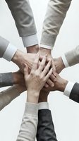 Business team hands stacked together in unity gesture showing collaboration, teamwork and partnership in corporate environment.