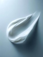 Smooth white cream swirl on gray background showing luxurious cosmetic texture and moisturizing properties for skincare advertising and beauty product promotion.