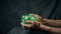 Elderly hands gently holding glowing green earth globe symbolizing environmental protection and sustainability for future generations.