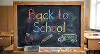 Back to school colorful chalk text on blackboard with apple, pencil and bus drawings. Educational classroom concept for students returning to studies.