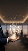 Businessman in dark suit holding glowing lightbulb with dollar sign symbol and golden particles, representing financial innovation, investment ideas, and business growth opportunities.