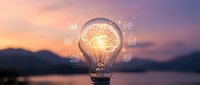 Glowing light bulb with brain and financial icons floating around it against sunset landscape backdrop, representing innovation, creativity, and business strategy.
