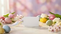 Easter greeting card mockup with colorful eggs, spring tulips and cherry blossoms on soft pastel background for holiday design projects.