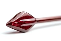 Red glass arrow tip on metal shaft against white background, macro photography showing transparent crystalline structure and light reflections.