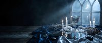 Gothic medieval interior with ornate silver chalice, lit candles and draped fabric creating mysterious atmospheric scene for fantasy storytelling projects.