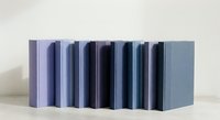 Row of hardcover books in various shades of blue and purple standing upright, minimalist design for educational and literary concepts.