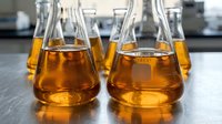 Laboratory glassware with amber liquid samples in modern research facility for chemical analysis and scientific experimentation.