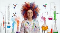 Young female scientist with curly red hair and glasses in laboratory with colorful chemical reactions and molecular structures around her head.