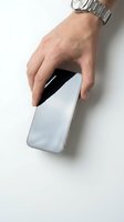 Male hand with silver watch holding a modern smartphone with blank screen on white background, mockup ready for app or UI design.