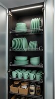 Modern kitchen cabinet interior with organized mint green dinnerware on wire shelves featuring LED lighting for efficient storage and display solutions.