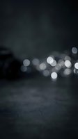Abstract dark background with soft bokeh lights creating dreamy atmosphere for modern design projects and creative presentations.