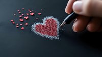 Hand drawing glitter heart shape with silver sparkles and small red hearts scattered on dark background, romantic creative Valentine concept for greeting cards.