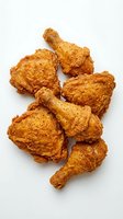 Crispy fried chicken pieces with golden-brown seasoned coating isolated on white background, ready for food photography, restaurant menus, and culinary design projects.