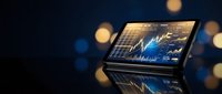 Laptop displaying financial charts and trading data on screen with bokeh lights background for business analysis and investment monitoring.