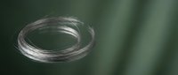 Transparent glass ring or circular tube isolated on blurred green background, suitable for design overlays, web graphics, and digital compositing projects.