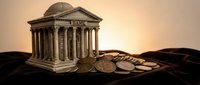 Classical bank building with columns standing on pile of coins representing financial stability and wealth management services.