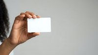 Close-up of a hand holding a blank white card against a neutral background, suitable for branding, business presentations, and marketing materials.