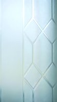 Frosted glass window with geometric diamond pattern creates elegant privacy screen for modern interior design and architectural applications.