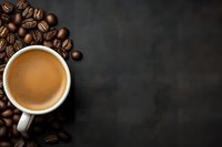 Cup of fresh espresso surrounded by roasted coffee beans on dark background with copy space for menu or recipe.