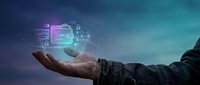 Business professional holding holographic digital interface with data analytics and technology elements floating above palm against gradient background.