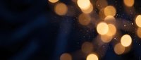 Abstract golden bokeh lights on dark blue background creating magical atmosphere for luxury design projects and festive celebrations.