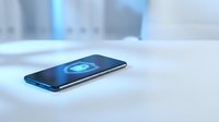 Modern smartphone with wireless charging technology displaying blue energy waves on screen in minimalist tech environment for digital innovation concepts.