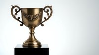 Golden bronze trophy cup with ornate handles on black base against white background, isolated award symbol for achievement recognition and victory celebration.
