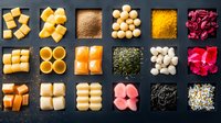 Colorful Japanese mochi and wagashi sweets collection arranged in grid pattern on dark background, traditional Asian desserts and spices assortment.