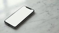 Modern smartphone with blank white screen lying on marble surface for app mockup and digital presentation projects.
