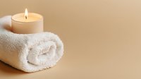 Glowing candle on rolled white spa towel against beige background creates serene wellness atmosphere. Minimalist composition for relaxation and meditation.