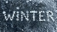 Word winter written with snowflakes on frozen dark surface, cold season concept with icy texture and frost crystals for seasonal design.