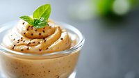 Creamy coffee mousse dessert with swirled whipped topping and fresh mint garnish in glass cup, perfect for cafe menu and gourmet food photography.