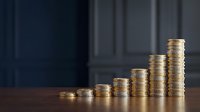 Golden coins stacked in ascending rows showing financial growth and investment success on wooden surface against dark background.