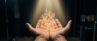 Cupped hands holding glowing flame symbolizing hope, protection and spiritual energy in dramatic lighting for inspirational and motivational concepts.