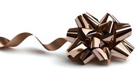 Elegant bronze metallic gift bow with curled ribbon isolated on white background, featuring luxurious shiny finish and sophisticated design for festive occasions.