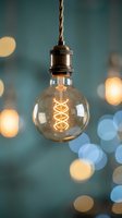 Vintage Edison bulb with spiral filament hanging from copper pendant light fixture against blurred bokeh background for modern interior design.