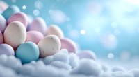 Pastel Easter eggs in soft pink and blue tones nestled in fluffy white clouds against dreamy bokeh background, creating magical spring holiday atmosphere.