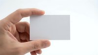 Hand holding blank white business card mockup template isolated on white background for branding and corporate identity design projects.