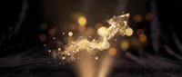 Open book with magical golden light particles and sparkles flowing upward creating enchanting atmosphere for fantasy storytelling and education concepts.