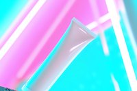 White cosmetic tube on vibrant neon pink and turquoise background with diagonal light streaks creates modern aesthetic for beauty and skincare marketing.