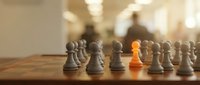 Wooden chess board with gray pawns and one golden pawn standing out, representing leadership, uniqueness, and strategic business advantage for corporate concepts.