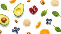 Fresh healthy superfood ingredients avocado blueberries pomegranate orange spinach quinoa walnuts almonds isolated on white background for nutrition diet.