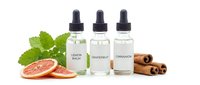 Natural essential oil bottles with dropper caps surrounded by fresh mint leaves, grapefruit slices and cinnamon sticks on white background for aromatherapy.