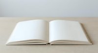 Open blank notebook with empty white pages on wooden surface ready for writing, journaling, sketching or creative projects.