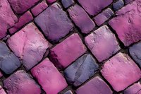 Pink and purple cobblestone pavement texture with rough surface and geometric pattern creates artistic urban background for design projects.