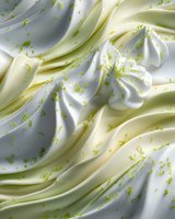 Creamy whipped dessert topping with lime zest sprinkled throughout, creating a fresh and tangy texture for culinary backgrounds.