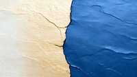 Dramatic contrast between cream and deep blue painted wall surfaces with natural crack and texture, creating abstract artistic composition for interior design.