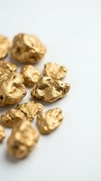 Raw gold nuggets scattered on white background showing natural metallic texture and irregular shapes for mining and precious metals concepts.